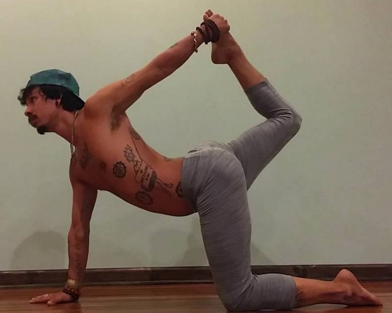 человек выполняет позу тигра, подняв руку и ногу